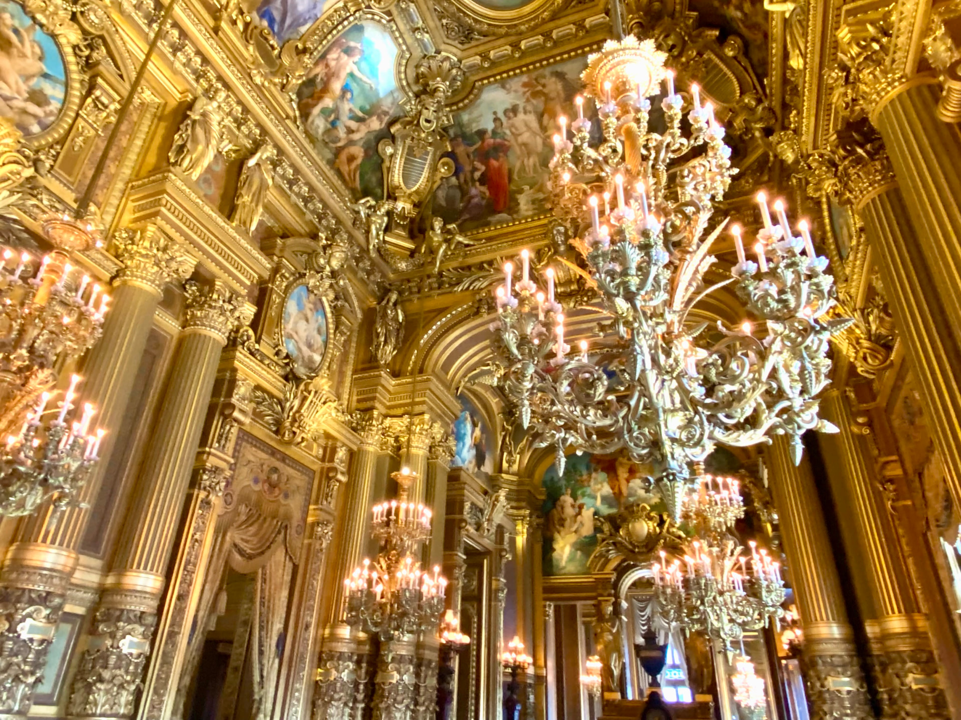 Gilded chandeliers and painted ceilings inside the Palais Garnier opera house in Paris, France