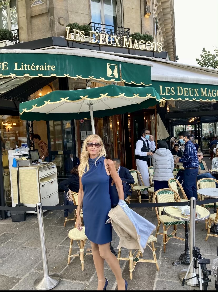 Classic Paris café terrace with woven chairs and marble tables in morning light, France
