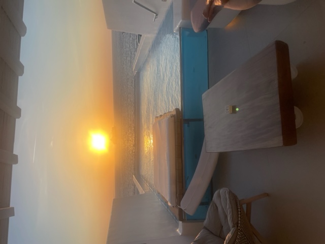 Sunset over a private terrace and pool above the Aegean sea in Santorini, Greece